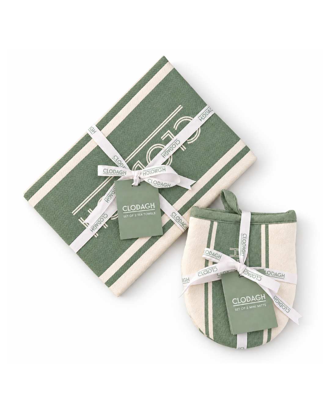 A Clodagh gift set featuring a folded green and cream striped towel and a matching oven mitt, both tied with white ribbon and a small branded tag, on a plain white background.