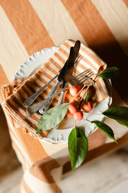Set of cutlery on a striped cloth with cherries and leaves