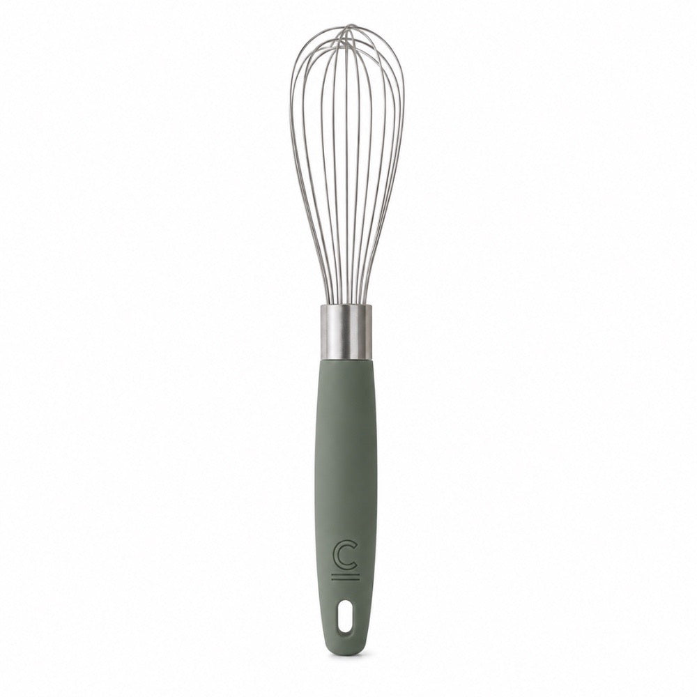A wire whisk with a matte sage green handle and a silver metal neck, featuring a debossed 'C' logo near the bottom, set against a plain white background.