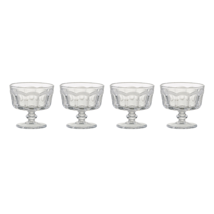 Set of four clear glass dessert bowls with decorative bases on a white background